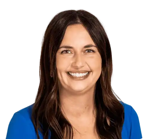 Professional woman smiling in blue blouse at Education Behavior Consultants office.