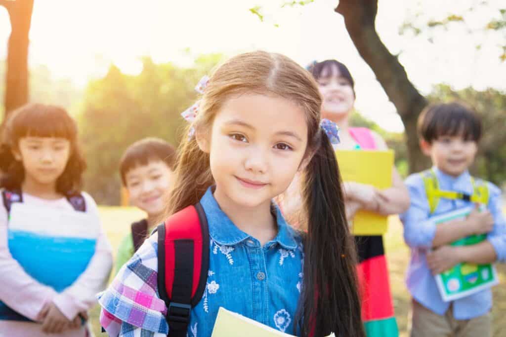 Happy school children with backpacks outdoor at play or break, promoting education, behavior, and social skills development.