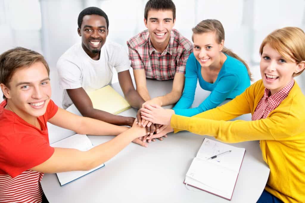 Diverse group of young adults and teenagers showing unity in an educational setting, promoting education behavior consulting.