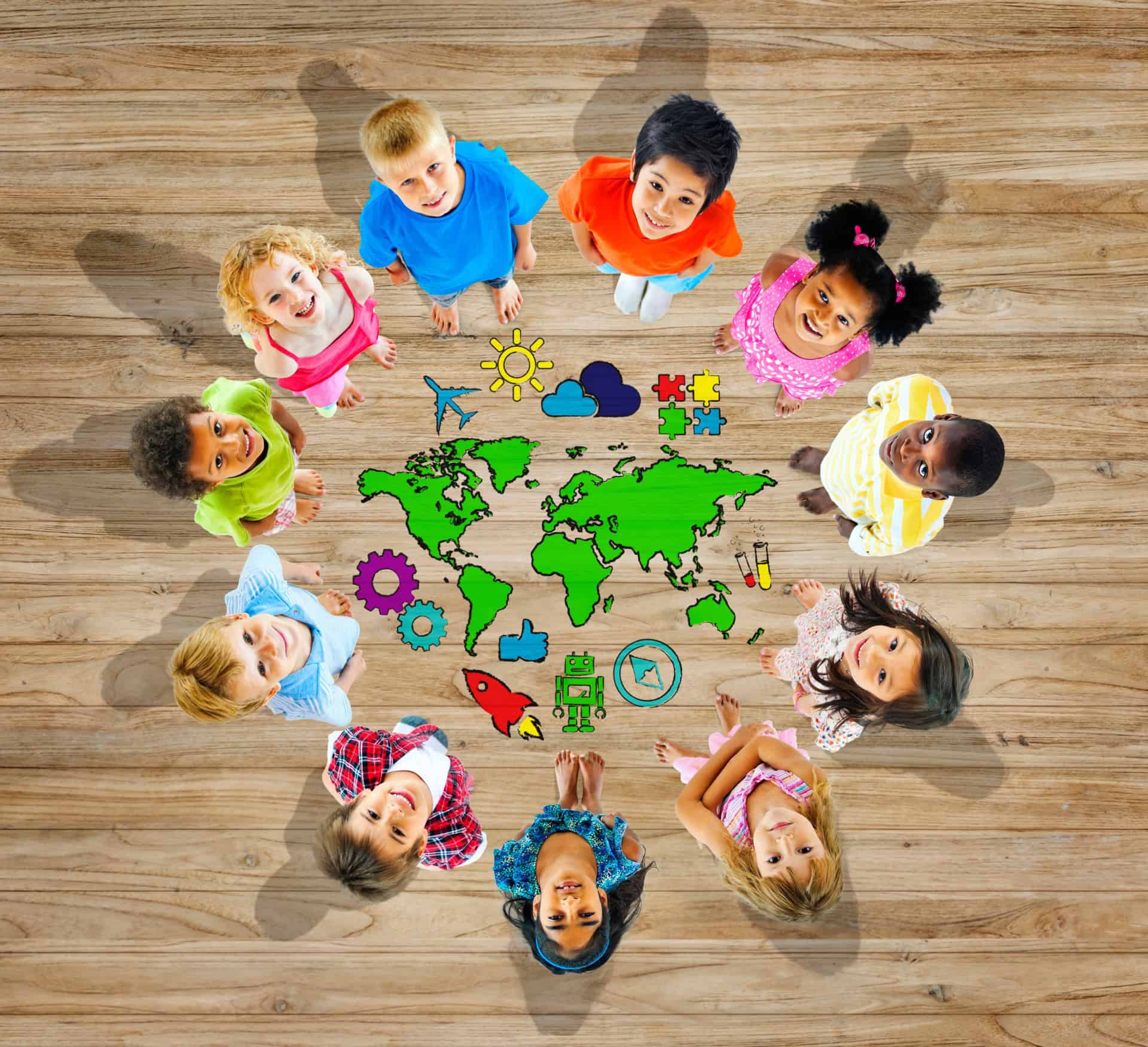 Children looking up at a colorful world map with icons, representing education, diversity, and global learning.