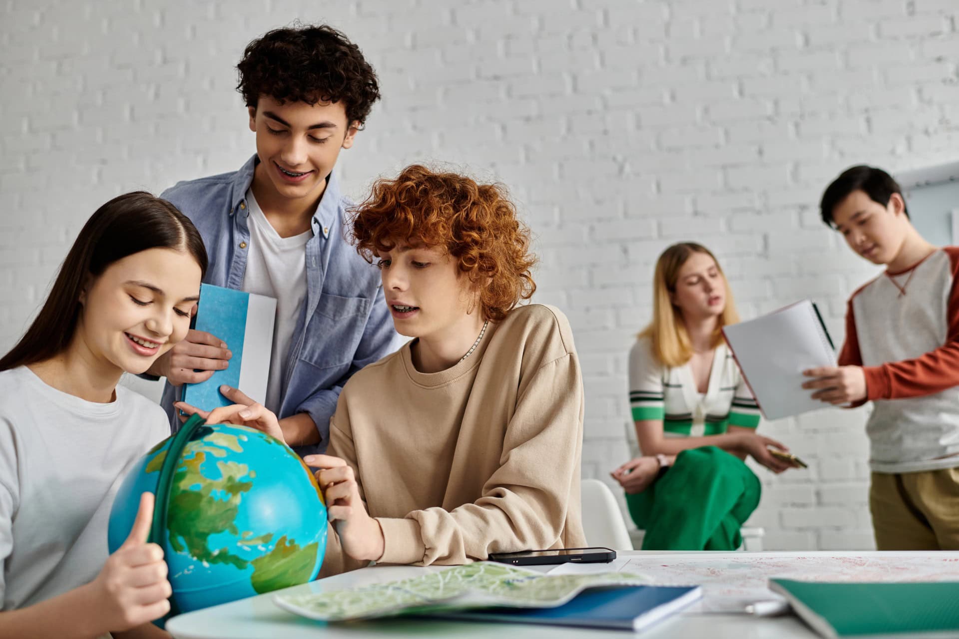 Bright diverse students collaborating on a geography project in a classroom.