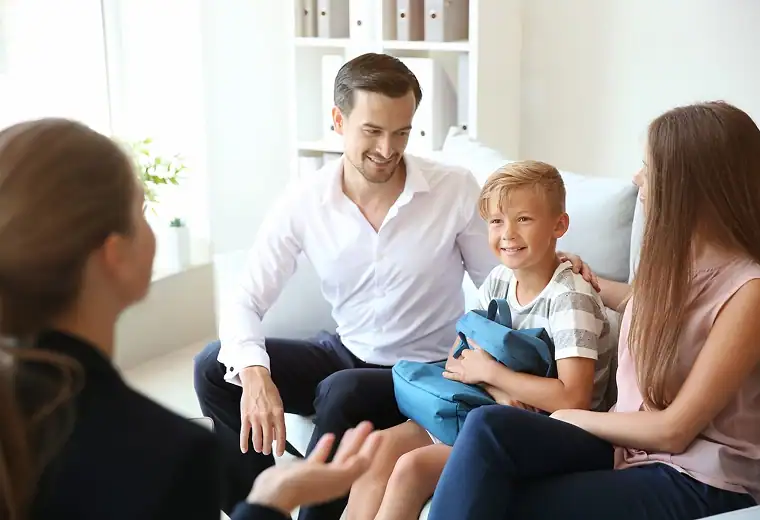 1. Caring counselor discussing behavior strategies with a happy young boy and his parents.