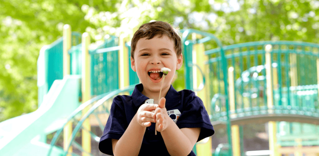 Happy boy enjoying outdoor play at the playground with bright equipment.