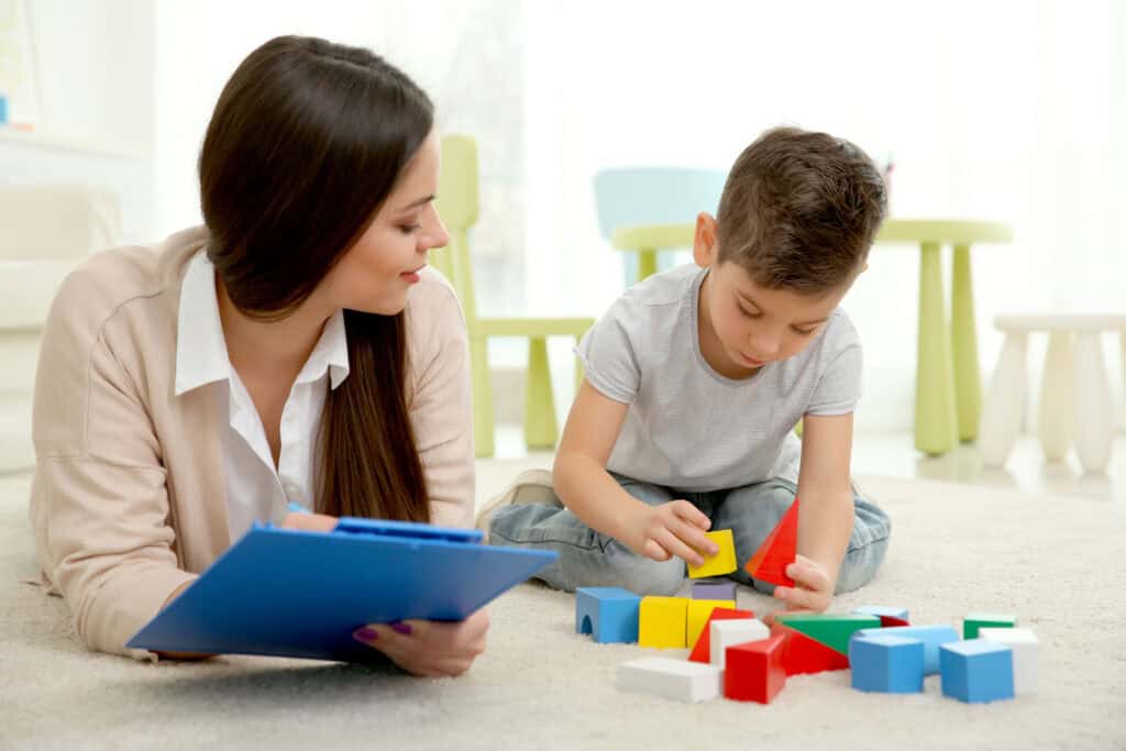 Autism therapy session with a child and therapist using educational toys.