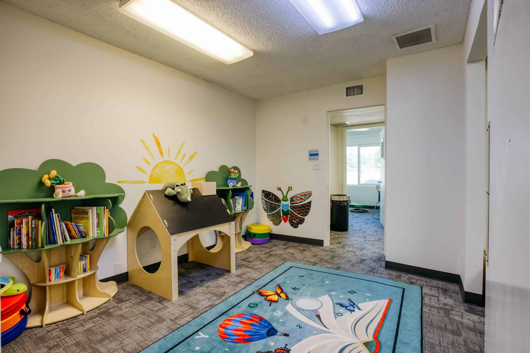 Child-friendly therapy room with books, toys, and colorful decor.