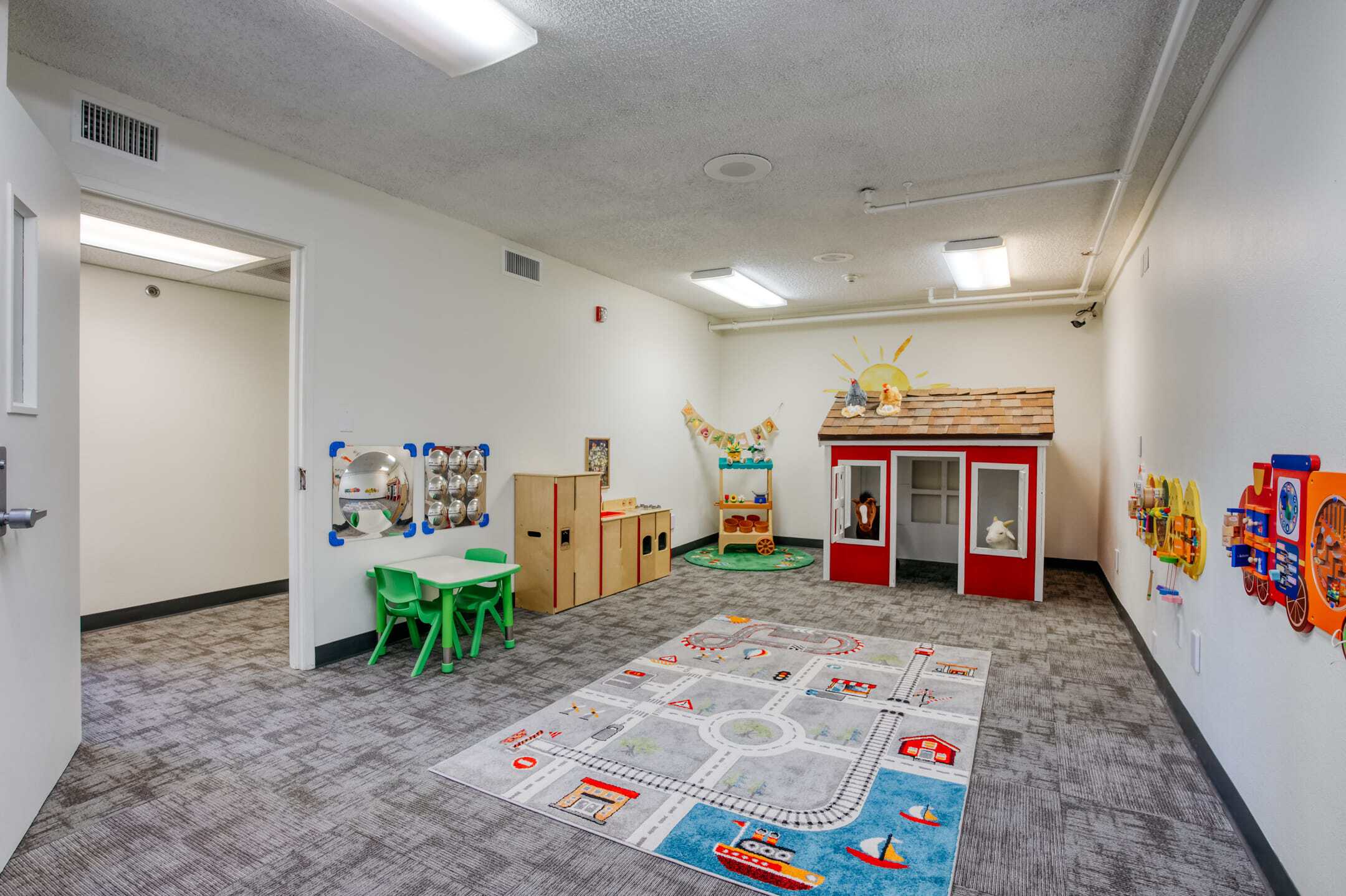 Bright, inviting classroom with toys, play area, and educational materials for children’s developmen.