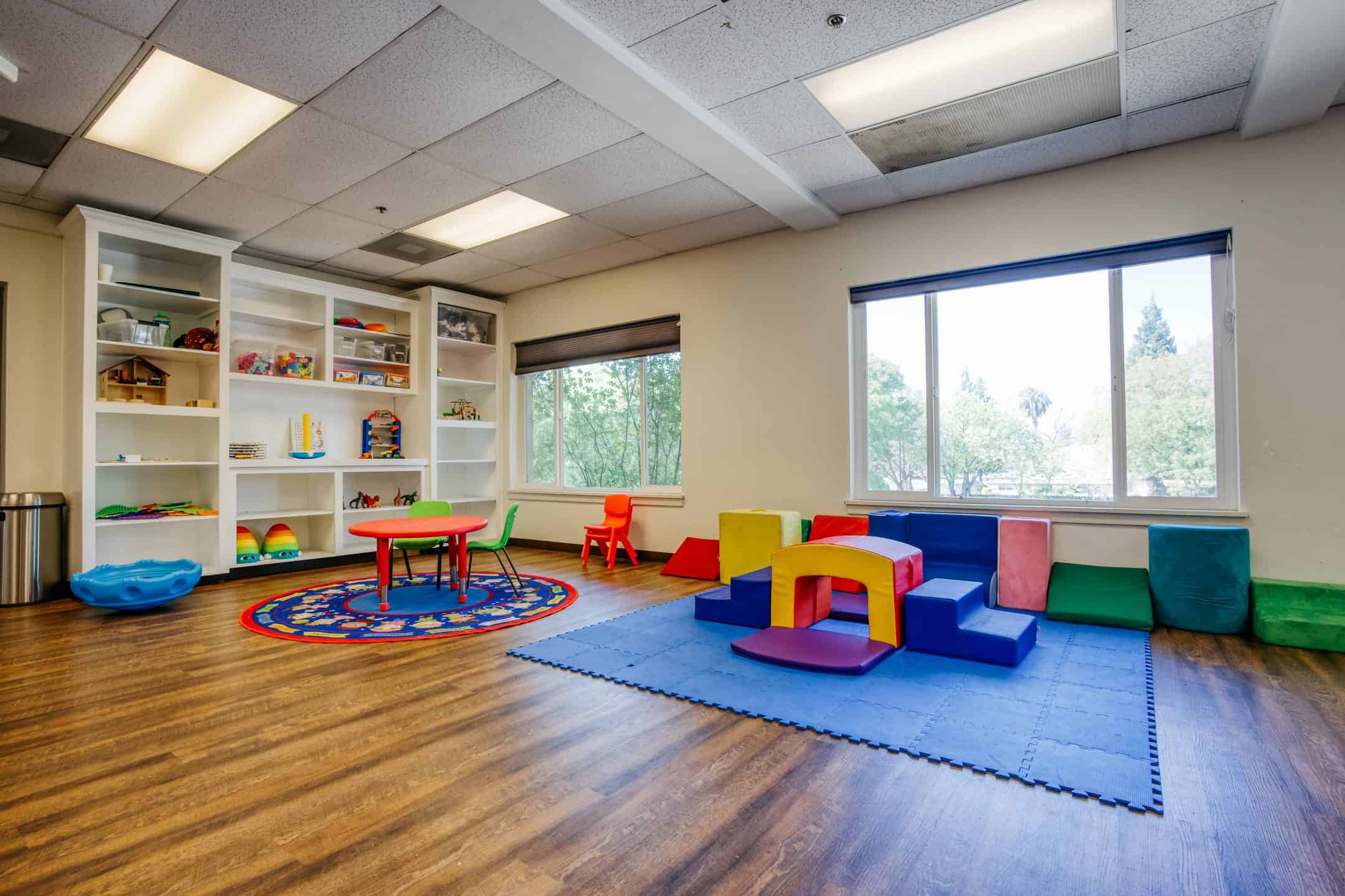 Bright and welcoming therapy room for children with colorful play equipment.