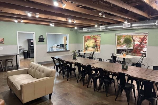 Spacious educational room with tables, chairs, and natural light.